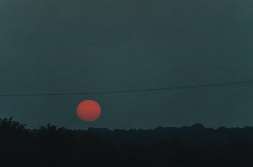 Sunset over a landscape with power lines in the foreground