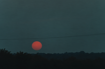 Sunset over a landscape with power lines in the foreground